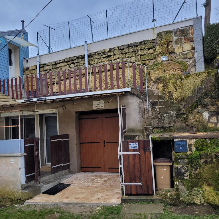 - un bâtiment avec une porte en bois et un balcon dans l'établissement Gite du vivier, à Loches
