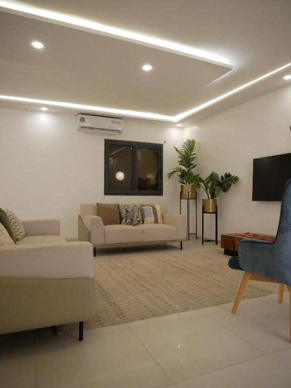 a living room with two couches and a flat screen tv at Résidence Bambou in Dakar