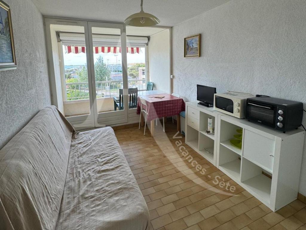 - un salon avec un lit, une télévision et une table dans l'établissement Studio cabine avec parking proche de la mer, à Sète