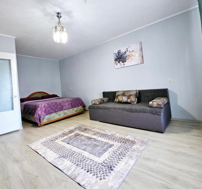 ein Wohnzimmer mit einer Couch und einem Bett in der Unterkunft Уютная квартира на Тверская 5, пр Правды, клиника Рохманова in Dnipro