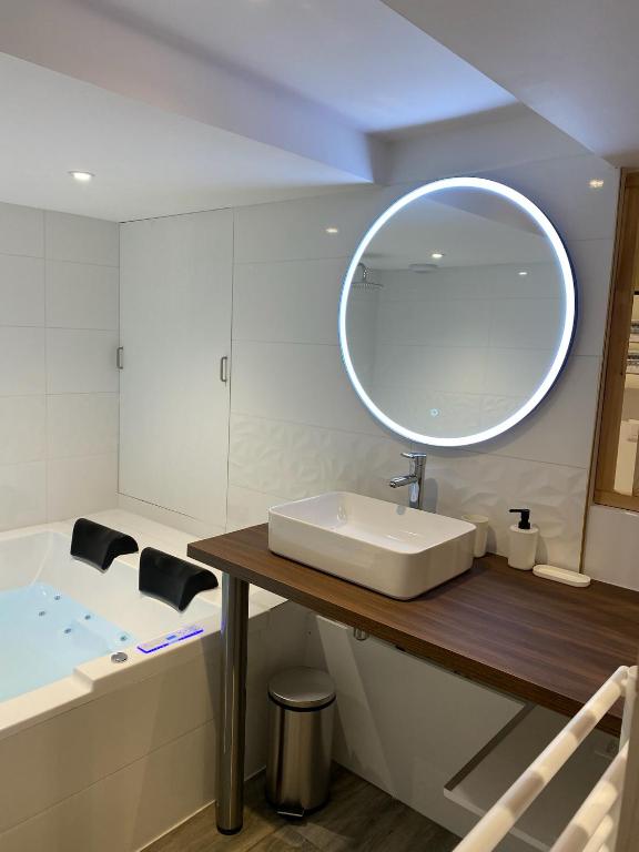 une salle de bain avec un lavabo, une baignoire et un miroir dans l'établissement Les Carmélites, à Rouen