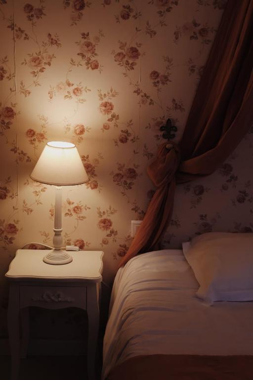 a bedroom with a bed and a lamp on a table at Château Sainte Colombe in Saint-Geniès-des-Mourgues