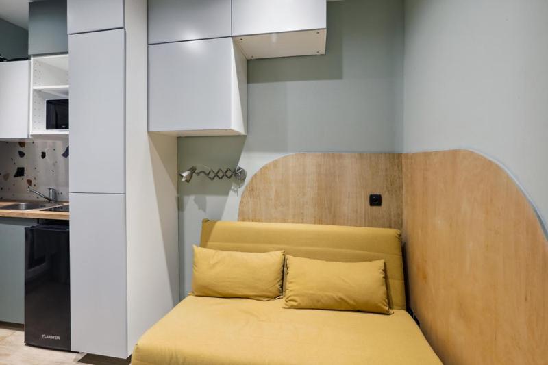 - un canapé avec deux oreillers dans la cuisine dans l'établissement 503 Suite Pergolèse - Charming Studio in Paris 16, à Paris