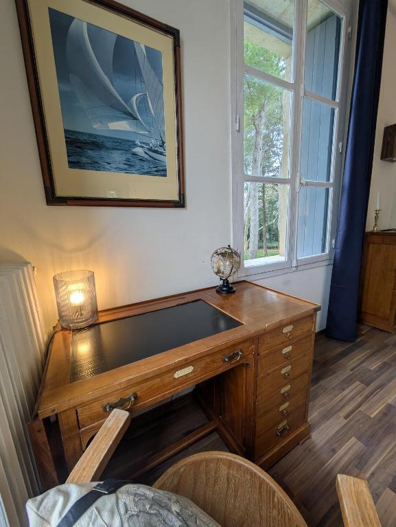 a wooden desk in a room with a window at Château Sainte Colombe in Saint-Geniès-des-Mourgues