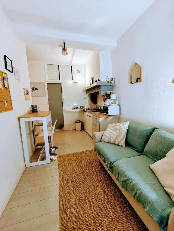 un salon avec un canapé vert et une cuisine dans l'établissement Baiona T2 Sainte Catherine Cœur de Saint Esprit, à Bayonne