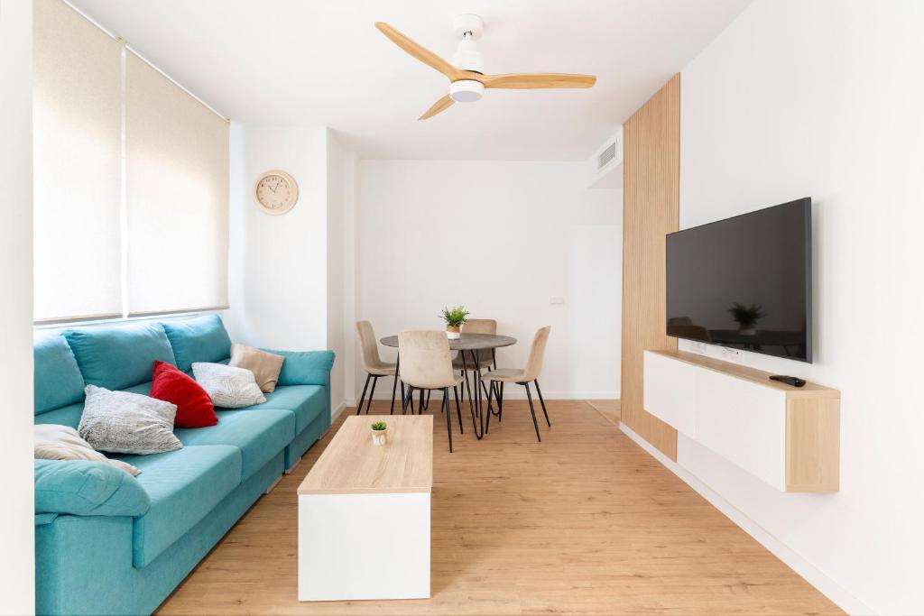 Una sala de estar con un sofá azul y una mesa. en Alojamiento Entero En Aguilas, en Águilas