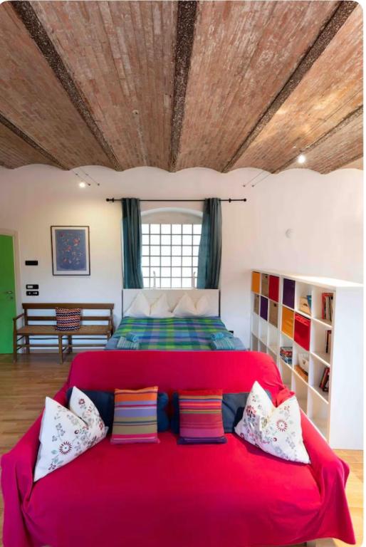 a bedroom with a large red bed with a wooden ceiling at Il Nido della Buonanotte 2 KIDS friendly in Verona