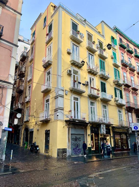 żółty budynek na ulicy miejskiej w deszczu w obiekcie La Casa Blu a Toledo di Alberto w mieście Neapol