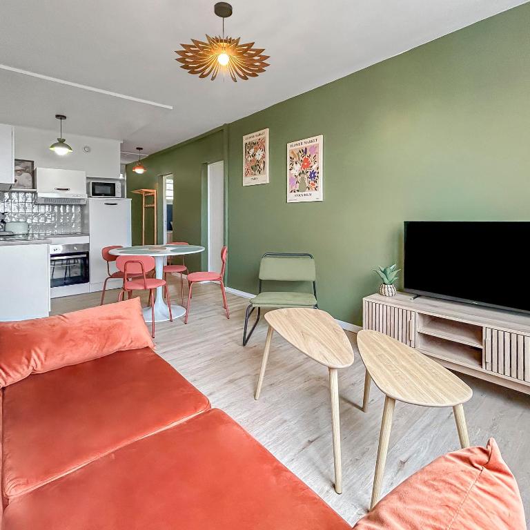 un salon avec un canapé, des chaises et une télévision dans l'établissement Cosy T3 Plein Centre, Clim & Balcon, à Toulouse