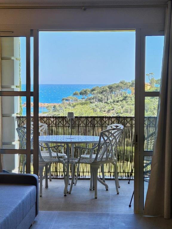 une table et des chaises sur un balcon avec vue sur l'océan dans l'établissement Nali CAP ESTEREL, à Saint-Raphaël