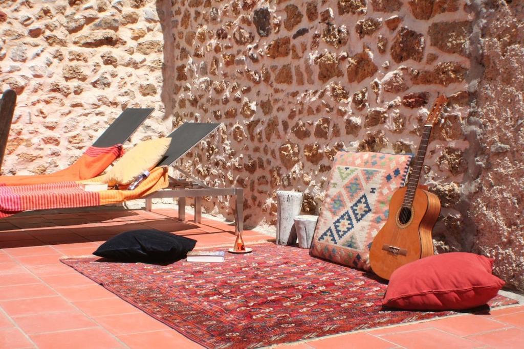 une chambre avec deux chaises et une guitare sur un tapis dans l'établissement Red sun and green tea, à Saint-Jean-de-Barrou