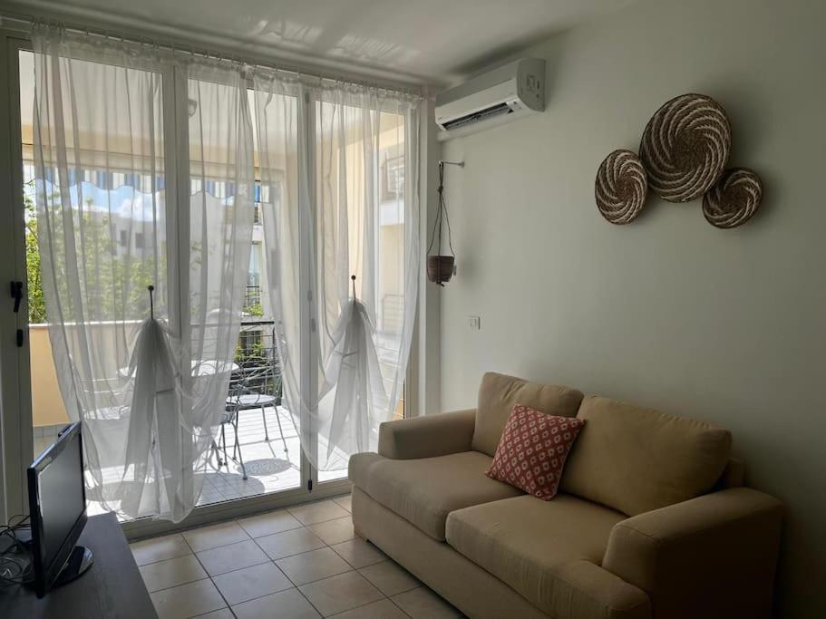 un soggiorno con un divano e una grande finestra di Casa-vacanze mare a Isca Marina