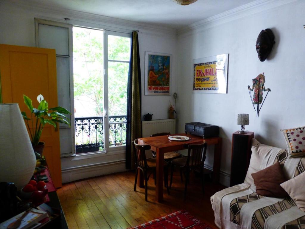 un salon avec une table et une fenêtre dans l'établissement Charming flat in Belleville, à Paris