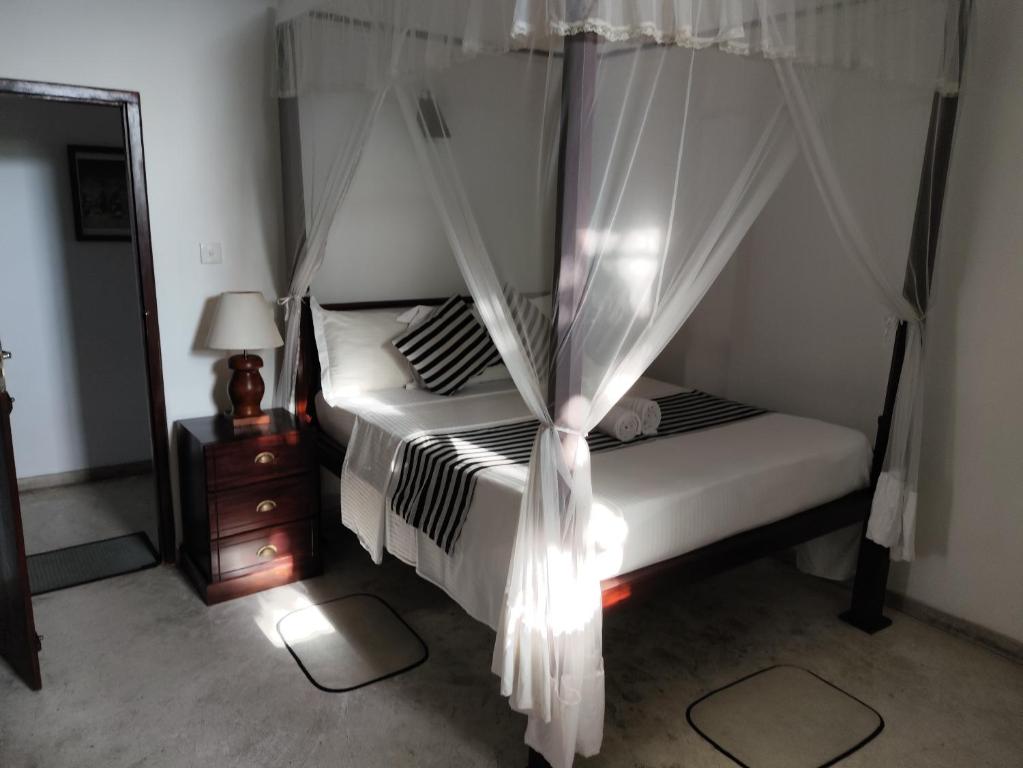 a bedroom with a bed with a canopy at Villa Uppugama in Etagama