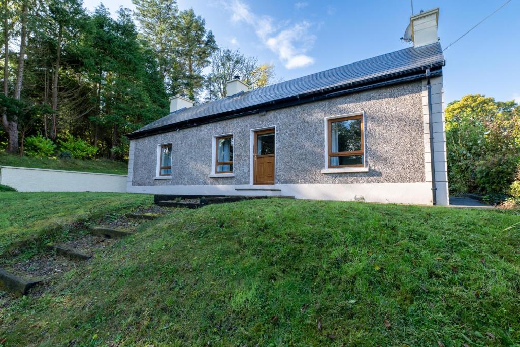 a house with a grassy yard in front of it at Herbie's Cottage in Letterkenny