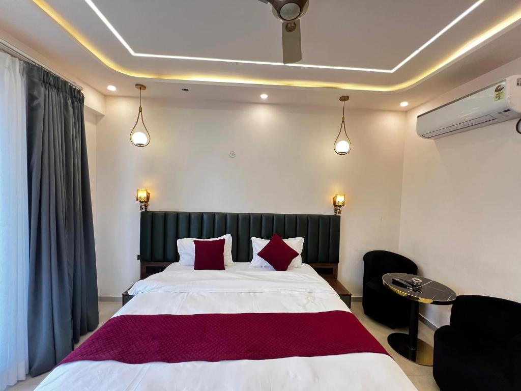 a bedroom with a large white bed with red pillows at Leisure homes in Lucknow