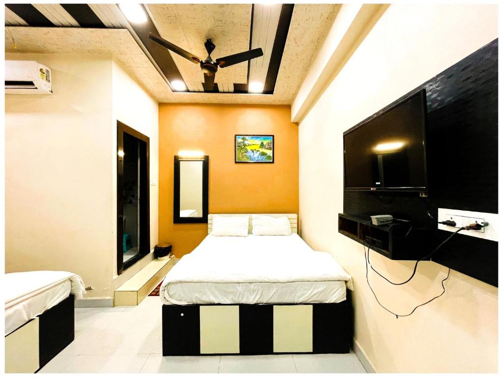 a bedroom with a bed and a flat screen tv at Hotel Pragati Heights in Mathura