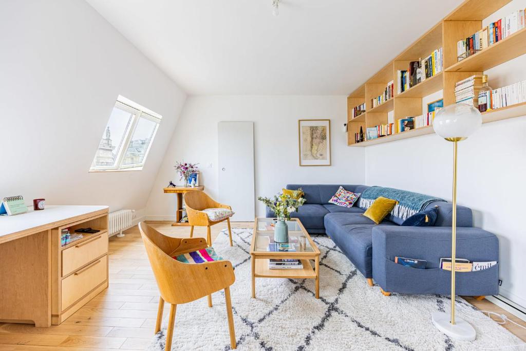 un salon avec un canapé bleu et une table dans l'établissement Appartement Compiègne - Welkeys, à Paris