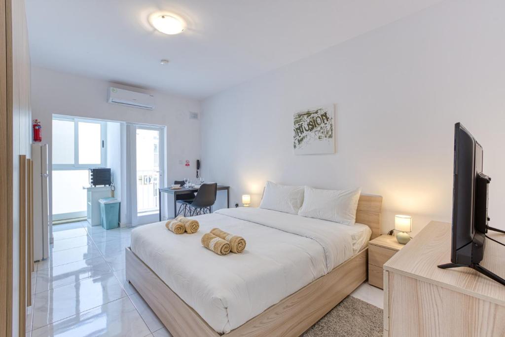 una camera da letto con un letto e una TV a schermo piatto di New Studio in Msida a Msida