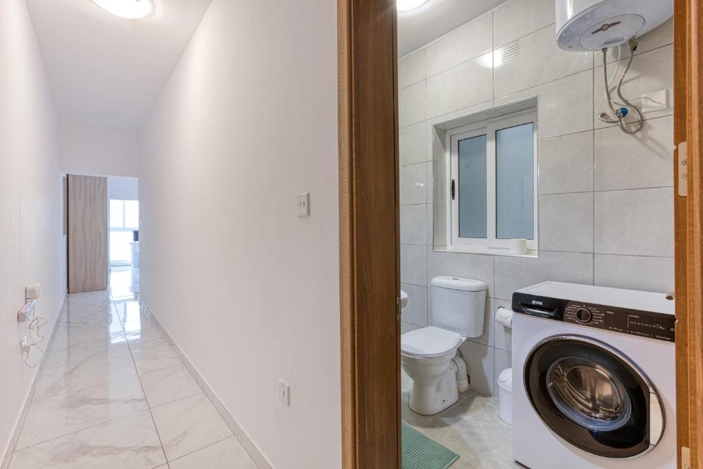 bagno con lavatrice e servizi igienici di New Studio in Msida a Msida