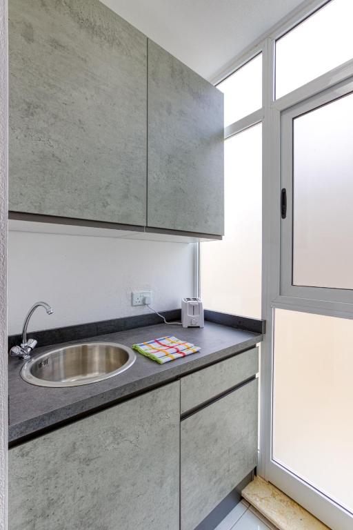 una cucina con un lavandino e una finestra di New Studio in Msida a Msida