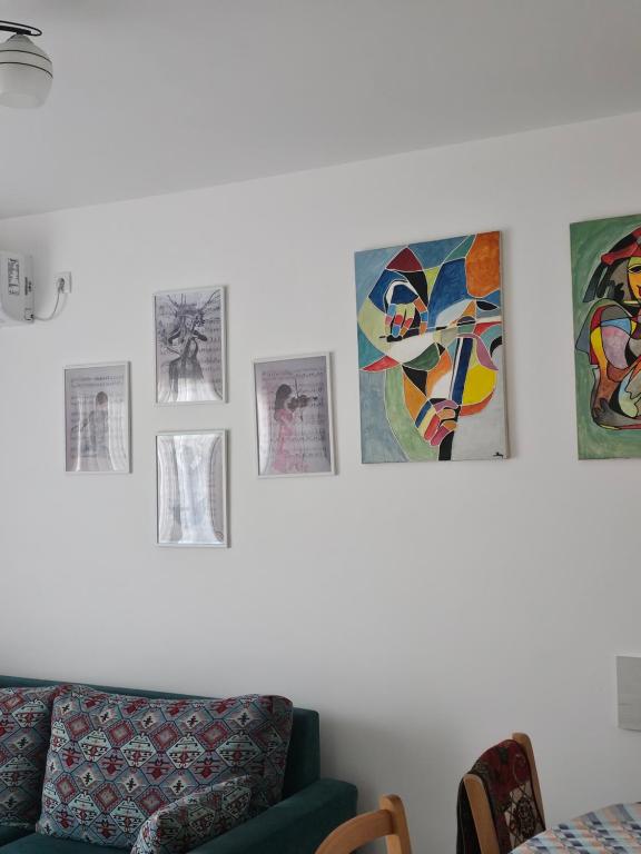 a living room with a couch and pictures on the wall at Apartman Sofija in Banja Koviljača
