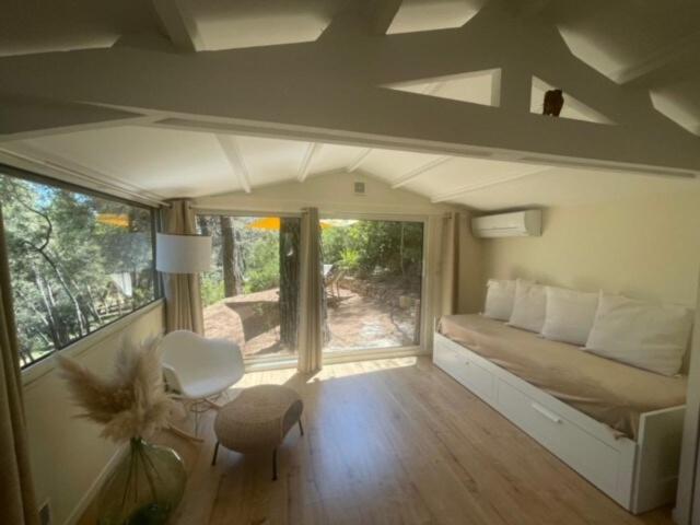 une chambre avec un lit et une pièce avec une fenêtre dans l'établissement Le Charmeur - Le Chalet Attrape-Coeur, à Aix-en-Provence