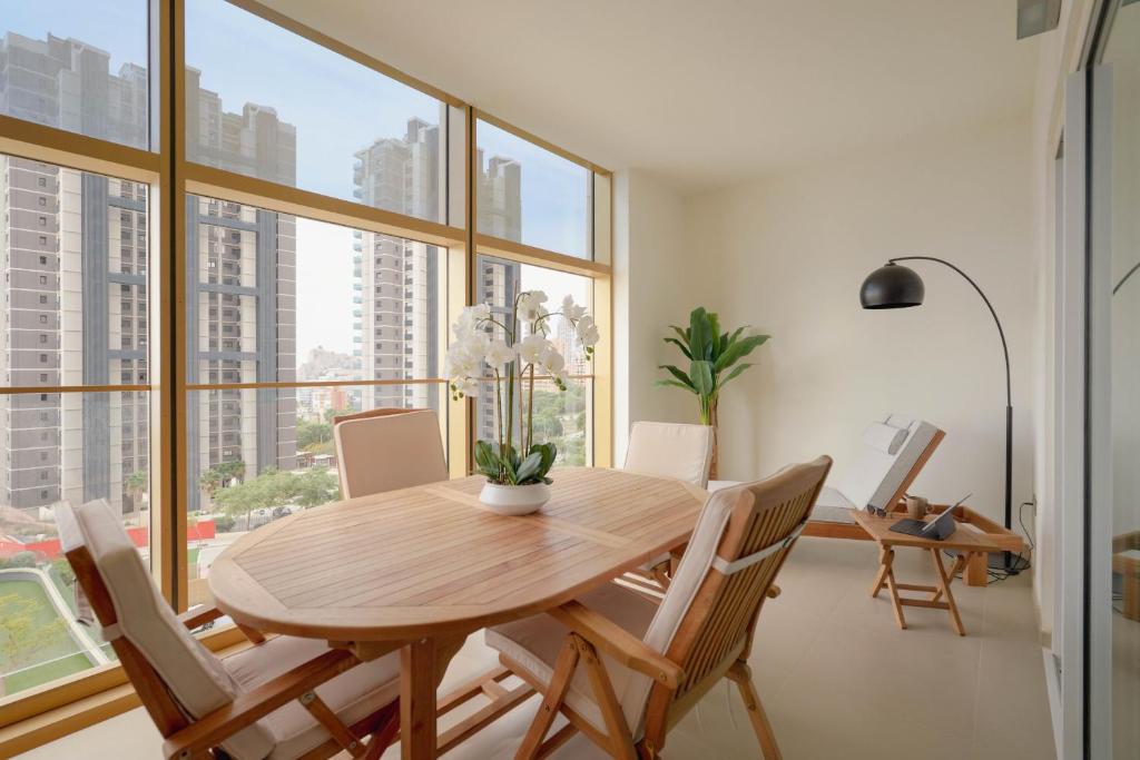 a dining room with a table and chairs and a large window at Intempo by Holuxe - 024 - 2nd floor in Benidorm