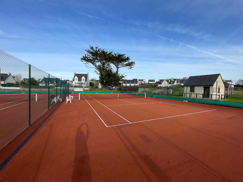 zwei Personen, die Tennis auf einem Tennisplatz spielen in der Unterkunft Ar Parc Bihan, vue mer! in Audierne