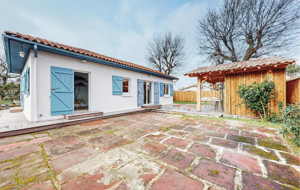 Cette maison blanche dispose de portes bleues et d'une terrasse. dans l'établissement Awesome Home In La Teste-De-Buch, à La Teste-de-Buch
