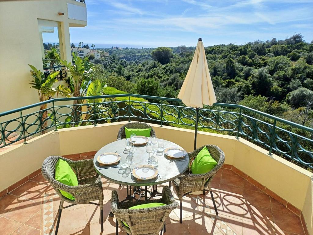 a balcony with a table and chairs and an umbrella at Casa Presa da Moura in Carvoeiro