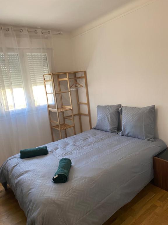 une chambre avec un grand lit avec deux oreillers dans l'établissement Studio meublé CIRCUIT 24h, au Mans