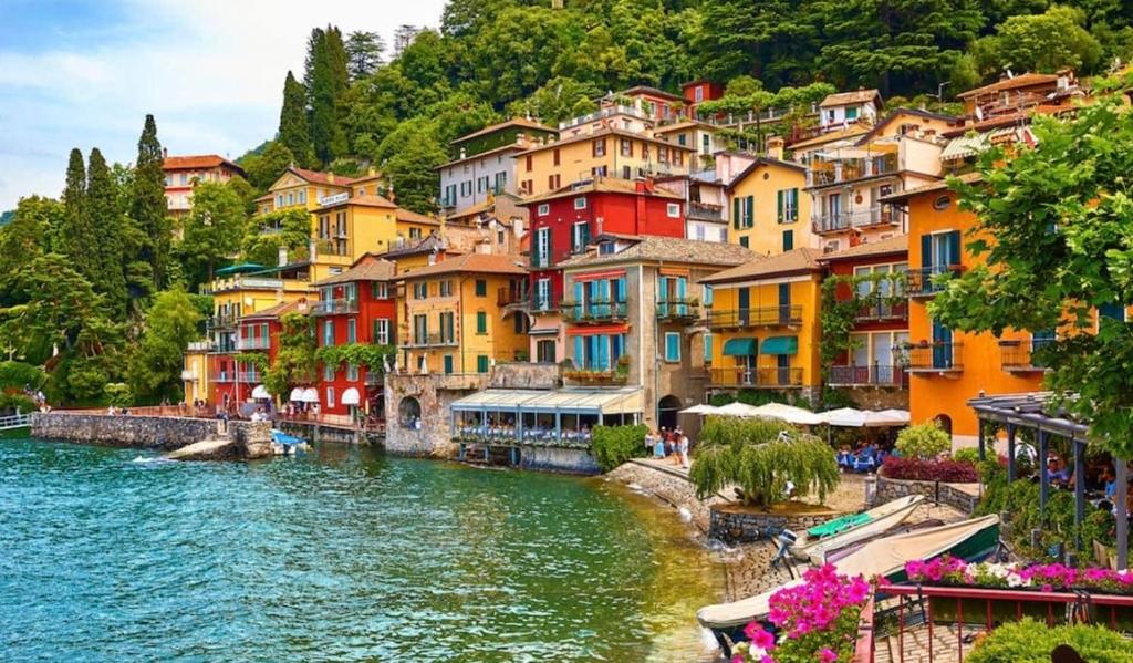a group of colorful houses next to a river at Sweet Love Varenna in Varenna