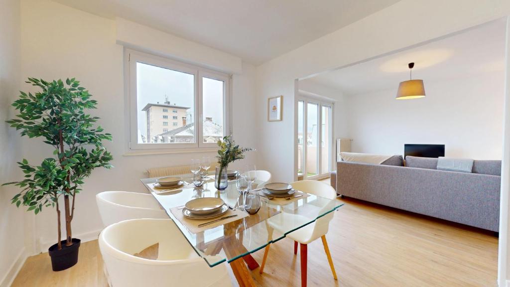 un salon avec une table, des chaises et un canapé dans l'établissement La belle étape avec parking, à Colmar