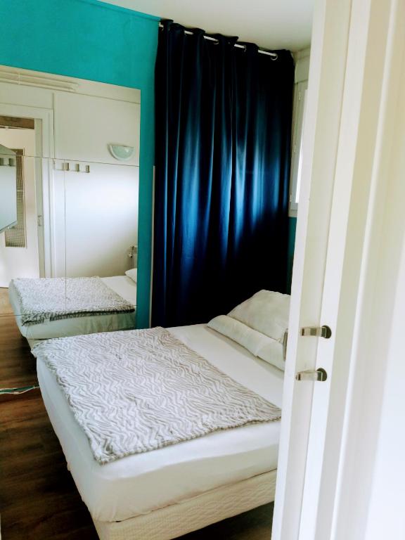 - une chambre avec 2 lits aux murs bleus dans l'établissement Royan congrés, à Royan