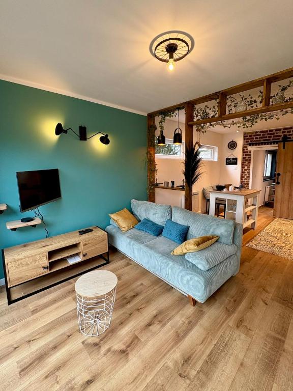 un salon avec un canapé bleu et une télévision dans l'établissement Au Ch'ti Cosy, à Roubaix