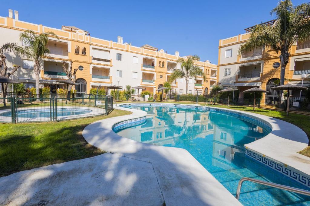 una piscina frente a un edificio en Costa Ballena - Apt para 6 con piscina, terraza, WiFi y parking gratis, en Rota