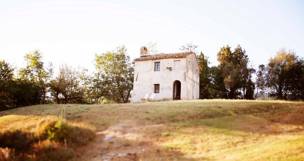 une vieille maison sur une colline dans un champ dans l'établissement Schulhaus, à Montecatini Val di Cecina