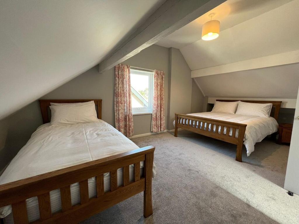 ein Schlafzimmer mit zwei Betten und einem Fenster in der Unterkunft The 100 House - Llandudno in Llandudno