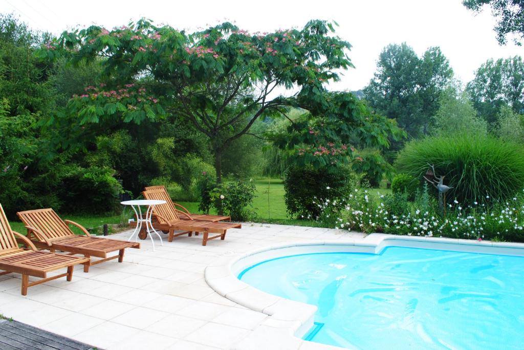 a patio with chairs and a swimming pool at Maison d'Hôtes Le Moulin Pointu in Sainte-Nathalène