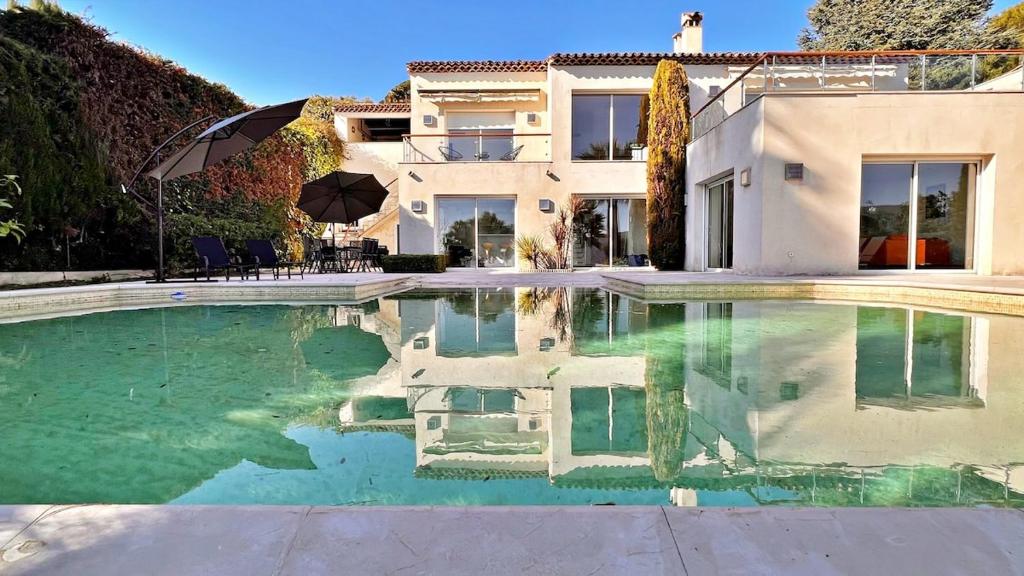 une maison avec une piscine devant une maison dans l'établissement Palm & Sun, à Nice