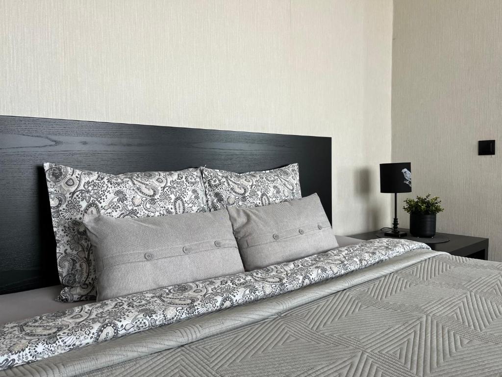 a bedroom with a large bed with a black headboard at Vienibas apartment in Daugavpils