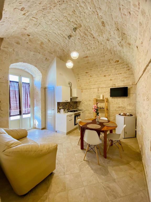 a kitchen and living room with a table and a couch at Rifugio Rosa in Castellana Grotte