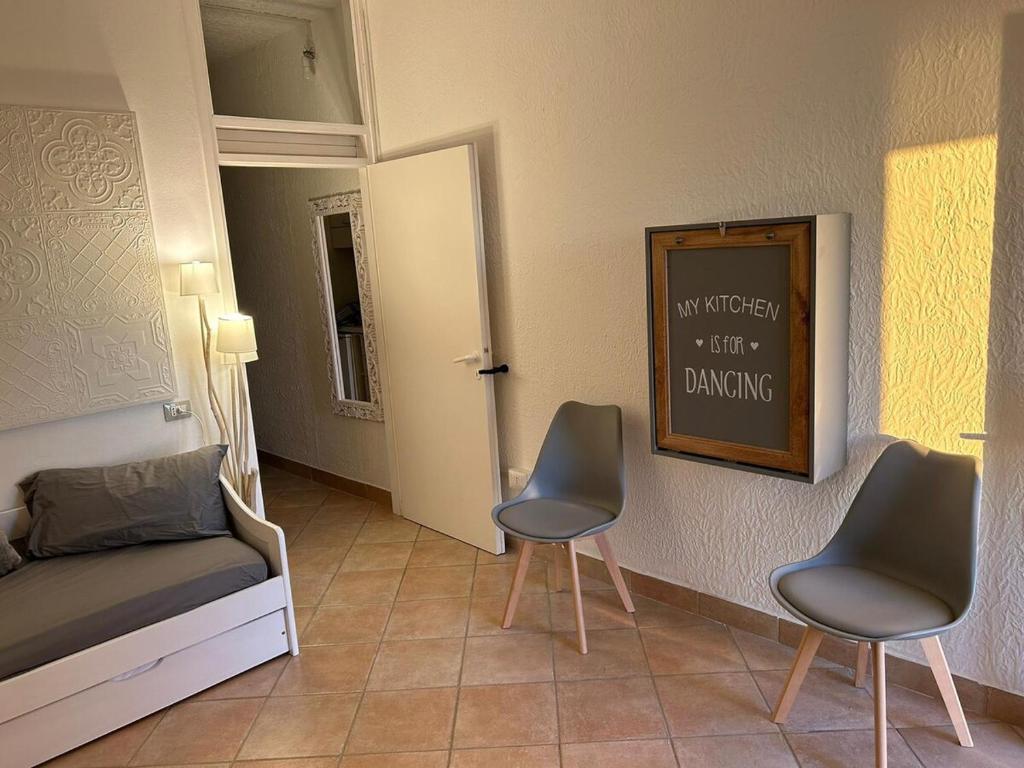 a bedroom with two chairs and a bed and a chalkboard at Il Paradiso è qui in SantʼAntìoco