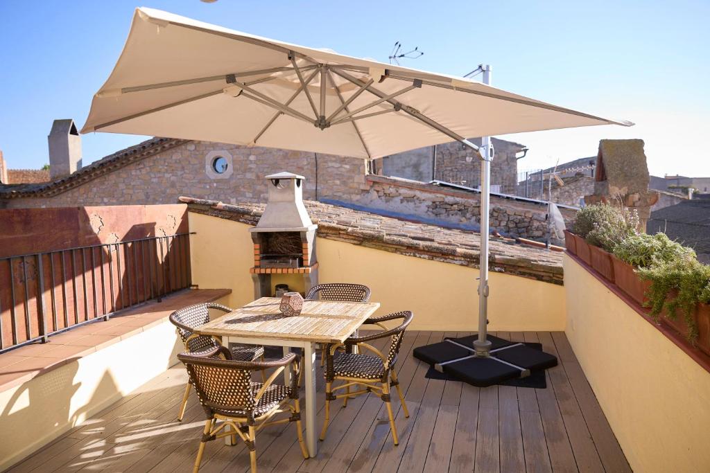 un tavolo e sedie con un ombrellone su un balcone di Encantadora Casa Rural para 4 personas en El Vilosell a El Vilosell