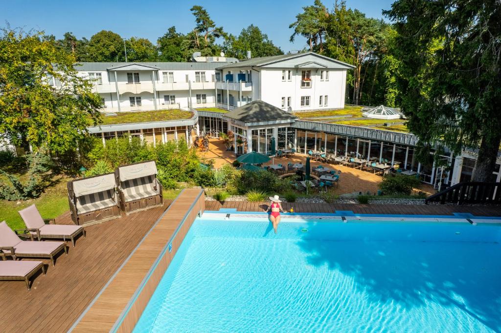 a person standing in the swimming pool of a hotel at Ostseehotel Villen im Park - ein Rovell Hotel in Bansin