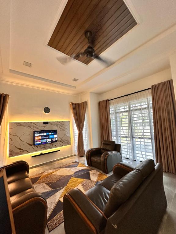 a living room with a couch and a tv at Homestay Husna in Dungun