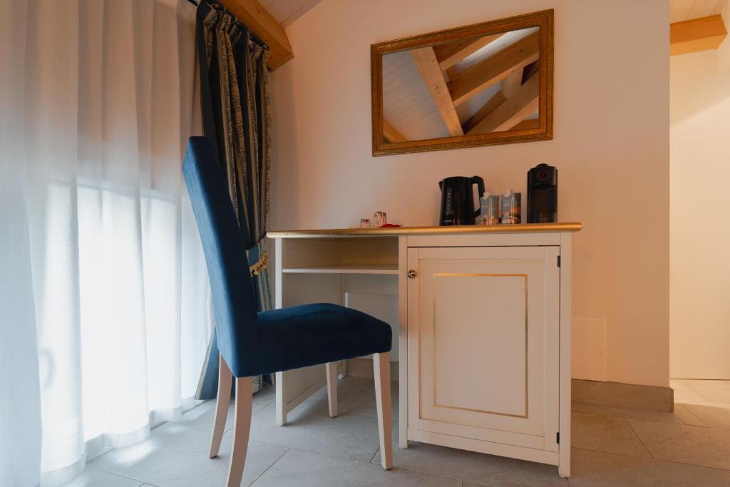 a blue chair sitting next to a desk with a mirror at FloVe' Rooms Venice in Venice