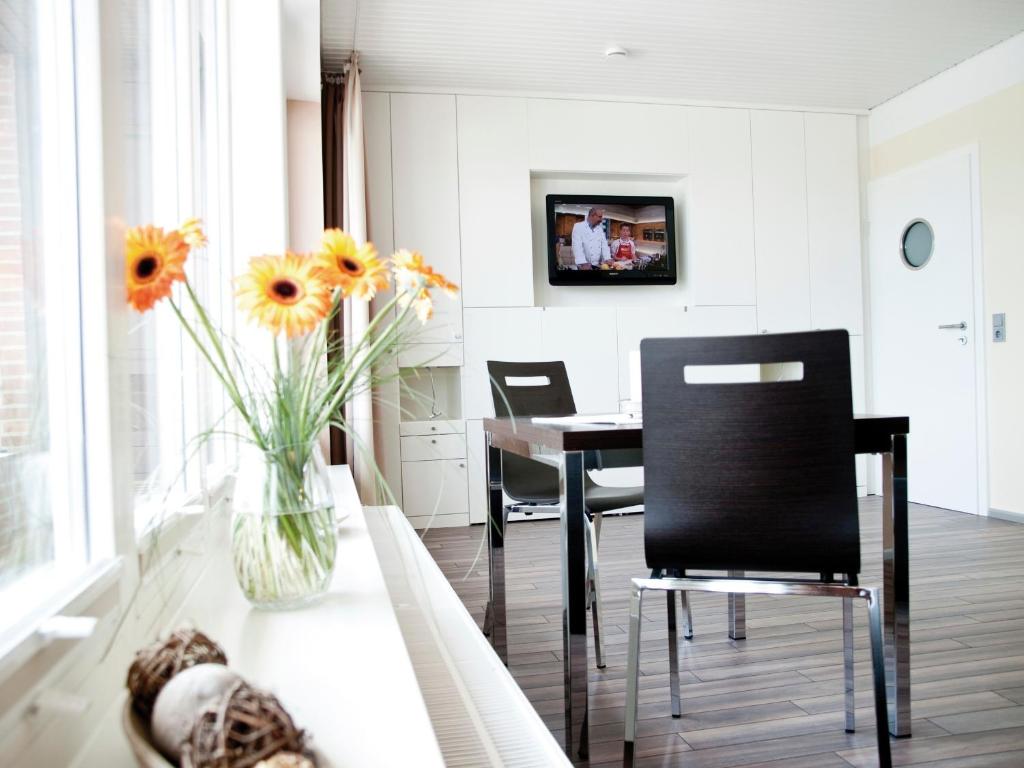 une salle à manger avec une table et un vase de fleurs dans l'établissement ancora Marina Haus 2 Nr 02, Typ 2, à Neustadt in Holstein