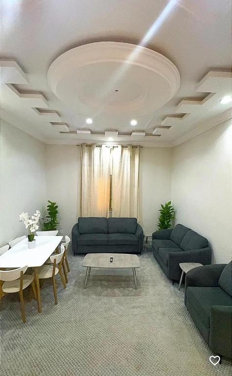 a living room with blue couches and a table at فيلا المروج الفندقية in Yanbu